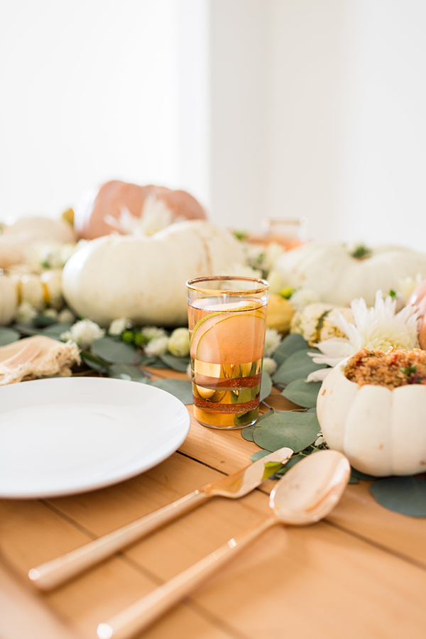 Gold gilded flatware, eucalyptus leaves, and colorful pumpkins...