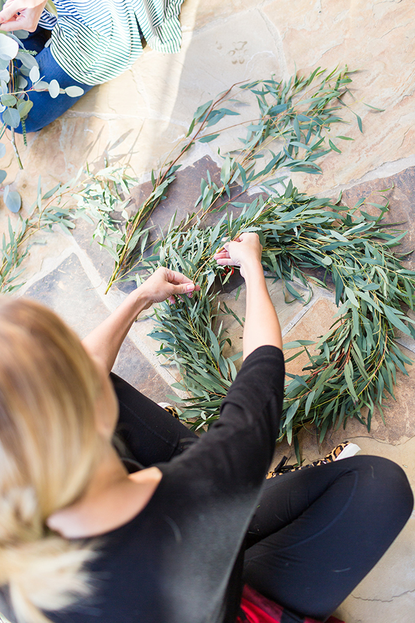 Fastening greenery to wire wreath bases.