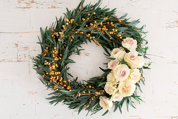 DIY holiday wreath with fresh greens and roses.