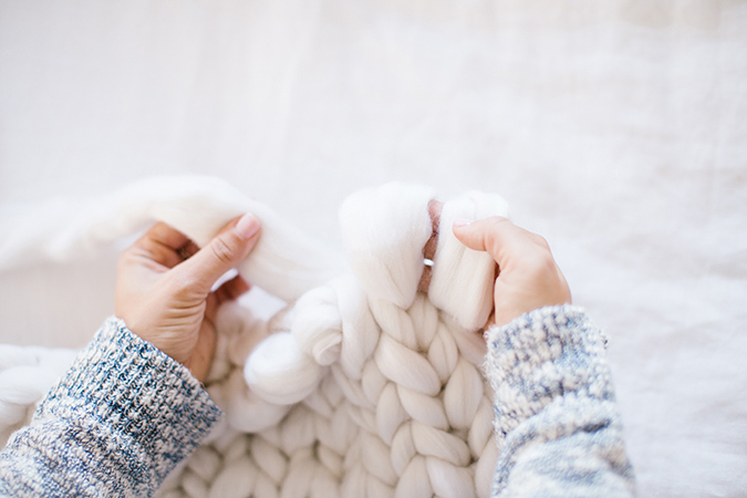 Knitted and Folded Chunky Blanket with Knitting Needles, Yarn Ball in Human  Hands on Neutral Background Stock Image - Image of craftsmanship, craft:  208859619